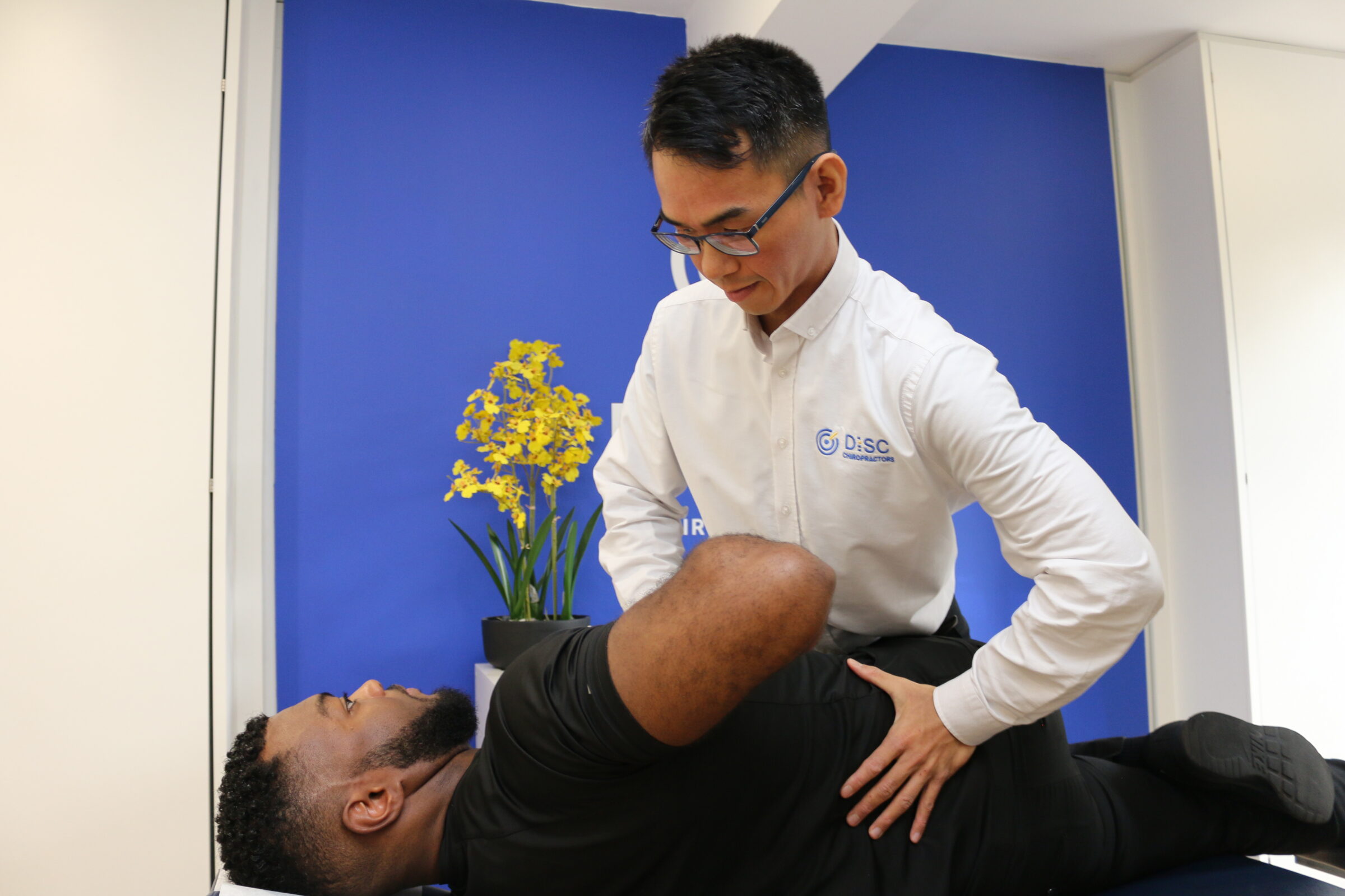 Kingston Chiropractor performing a spinal adjustment on a patient lying on a treatment table