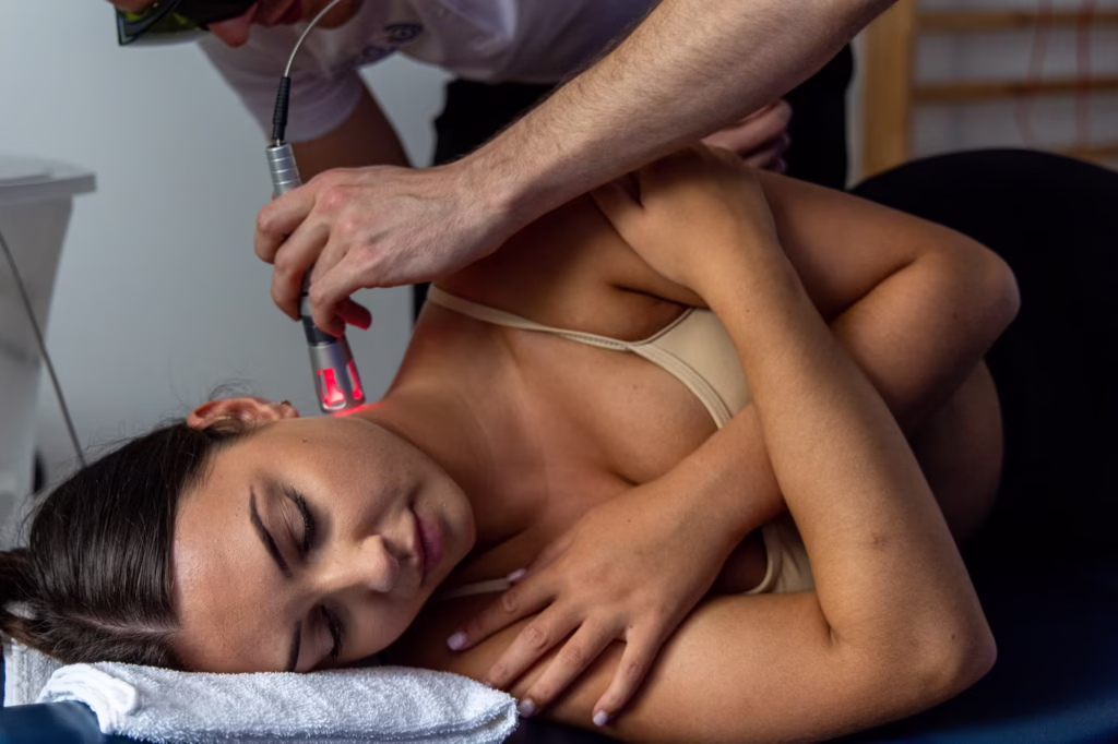 Woman receiving Class IV laser therapy on her neck during a chiropractic treatment session at a chiropractic clinic in Surbiton for neck pain relief and recovery.