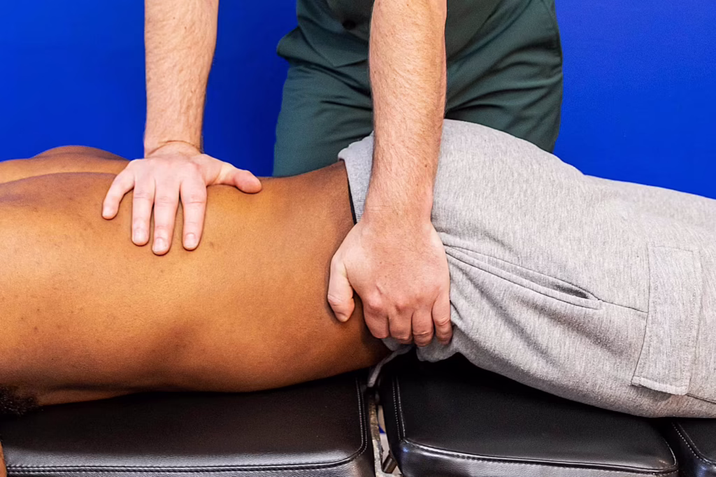 Surbiton chiropractor performing pelvic mobilisation treatment on a patient to improve hip and lower back mobility during chiropractic therapy.