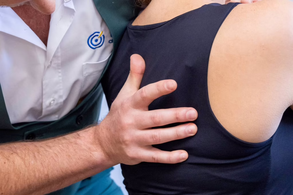 Chiropractor performing shoulder mobilisation treatment on a patient during a chiropractic session in Surbiton.