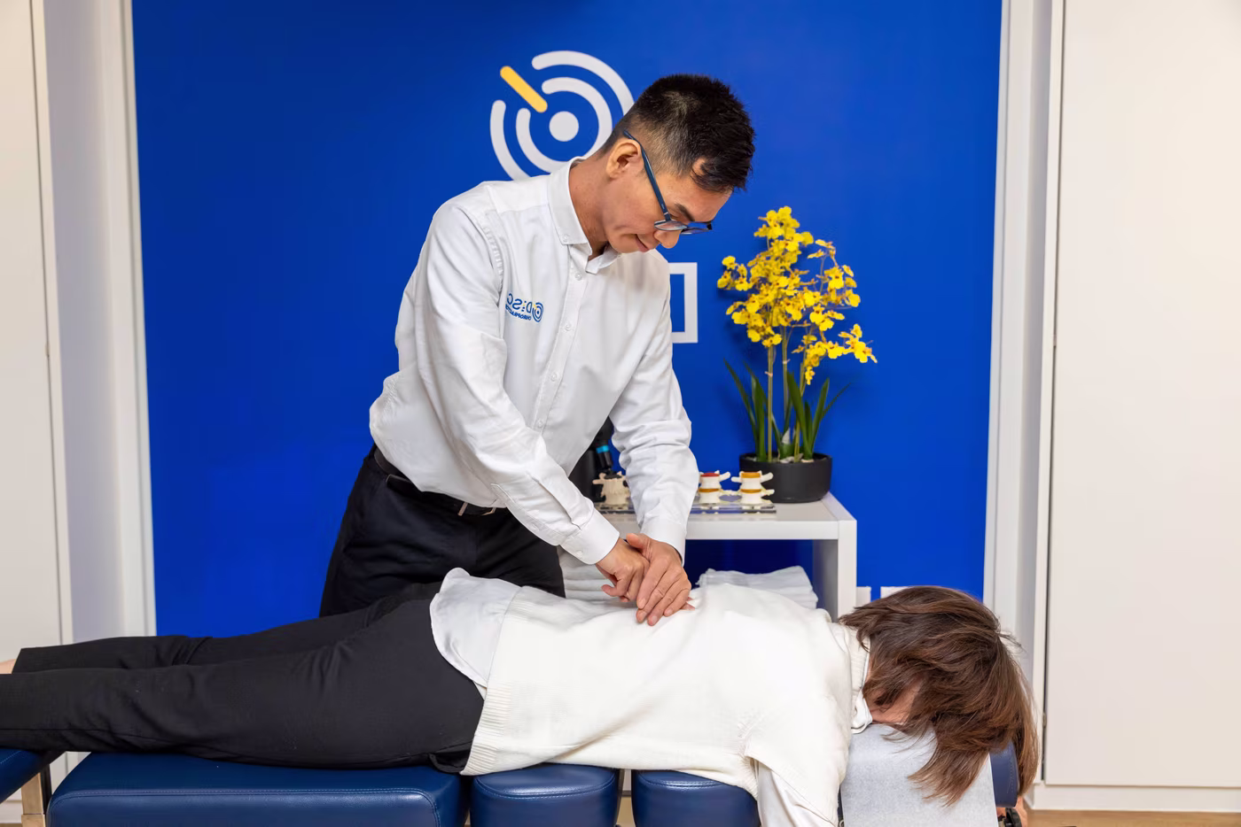 Chiropractor performing a thoracic spinal adjustment on a patient lying prone during treatment at a Surbiton chiropractic clinic.